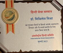 Service to Hindi Award, translated as follows: "The Service to Hindi Award by the International Hindi Association is given to Dr. Mithilesh Mishra for his extraordinary contribution and selfless dedication to Hindi."