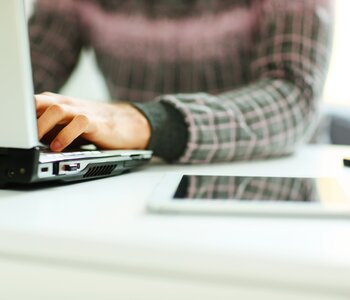 Close up of man typing on laptop