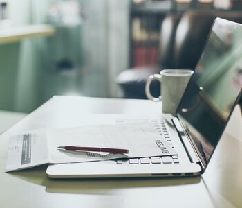 Office table with laptop, tablet, and form 