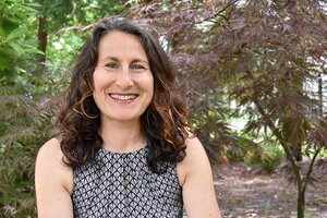 Smiling woman in sleeveless patterned shirt 