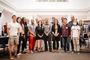 Group of new faculty members pose for picture at event 