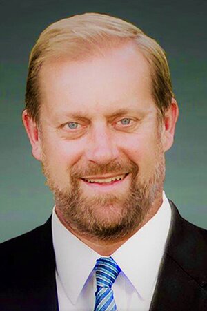 Smiling man in black suit and blue tie 