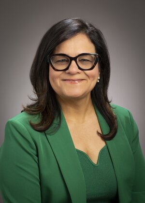 Smiling woman in green blazer and top