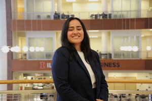 College student wearing a white shirt and black blazer poses for picture