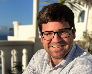 Smiling man with dark hair and glasses