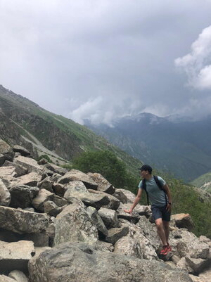 Student poses by mountain of rocks