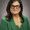 Smiling woman in green blazer and top